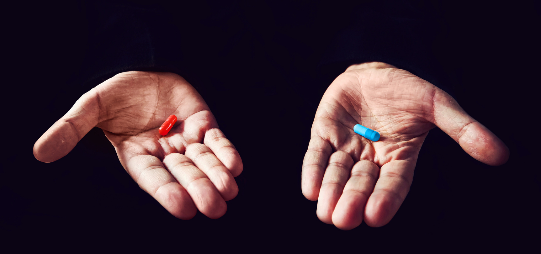 Deux mains tendues proposant chacune une pilule rouge et bleue, symbole d'un choix à faire rappelant le film "Matrix"
